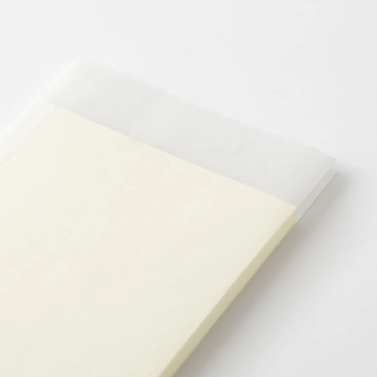 Papierowa, przezroczysta obwoluta na kremowym notatniku MD Product.
