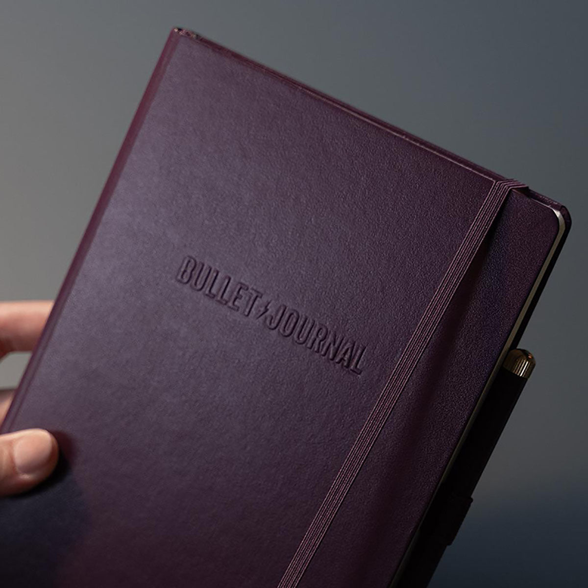 Notatnik w twardej oprawie ze skóry syntetycznej i napisem Bullet Journal.